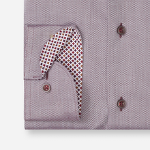 Load image into Gallery viewer, Close-up of a men's dress shirt cuff showing a patterned pocket square tucked into the turned-back cuff. The shirt has a fine micro-dot texture in a muted mauve-purple color, and the pocket square features a red, white, and gold geometric pattern.