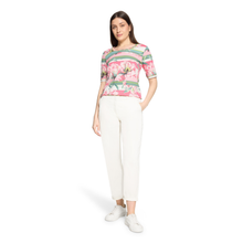 Load image into Gallery viewer, Woman wearing a floral top and white pants on a white background
