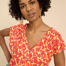 Load image into Gallery viewer, female model looking at camera wearing whitestuff top in orange colour with buttons showing on the front