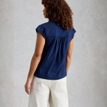 Load image into Gallery viewer, Woman wearing a navy blue sleeveless top and white pants against a gray background