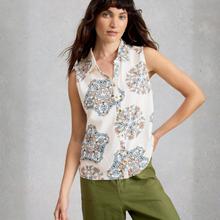 Load image into Gallery viewer, Woman wearing a sleeveless floral blouse with green pants against a gray background