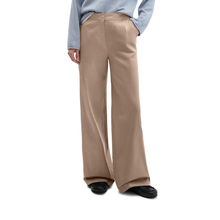 Load image into Gallery viewer, Beige wide-leg pants worn by a person on a white background