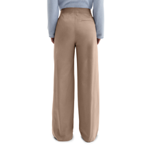 Load image into Gallery viewer, Beige wide-leg pants worn by a person on a white background
