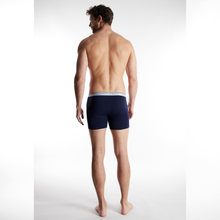 Load image into Gallery viewer, Man wearing navy blue boxer briefs on a white background