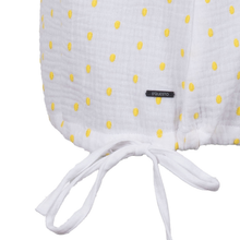 Load image into Gallery viewer, White muslin blanket with yellow polka dots and a visible brand label on a white background