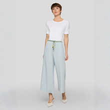 Load image into Gallery viewer, Woman wearing a white top and light blue wide-leg pants on a white background