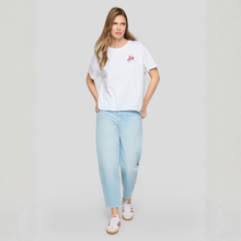 Load image into Gallery viewer, Woman wearing a white t-shirt and light blue jeans on a plain background