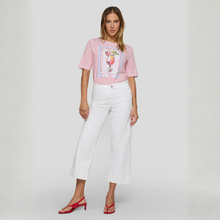 Load image into Gallery viewer, Woman wearing a striped shirt with a graphic design and white pants on a plain background