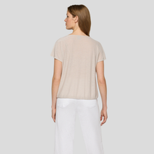 Load image into Gallery viewer, Woman wearing a beige top and white pants on a plain background