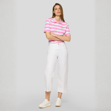 Load image into Gallery viewer, Woman wearing a pink and white striped polo shirt and white pants on a gray background