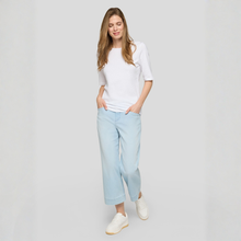 Load image into Gallery viewer, Woman wearing a white top and light blue pants on a plain background