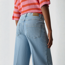 Load image into Gallery viewer, Person wearing light blue jeans and a pink and orange striped shirt on a plain background