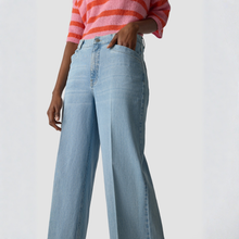 Load image into Gallery viewer, Person wearing light blue jeans and a pink and orange striped shirt on a white background