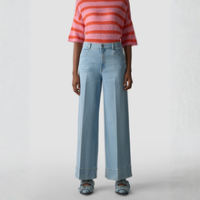 Load image into Gallery viewer, Person wearing a red and white striped sweater and light blue jeans on a white background