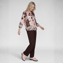 Load image into Gallery viewer, A woman modeling a long-sleeve blouse with a pink, brown, and beige abstract print, paired with dark brown trousers and light pink loafers, against a light gray studio background.