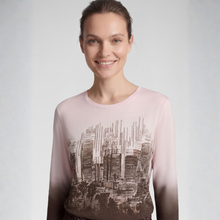 Load image into Gallery viewer, A woman wearing a sheer long-sleeve top with a gradient color transition from pale pink at the shoulders to dark brown at the hem, featuring a black and white cityscape graphic print across the front.