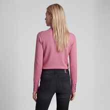 Load image into Gallery viewer, A woman with long blonde hair is shown from the back, wearing a dusty pink mock-neck long-sleeve top and dark gray jeans against a light gray studio background.