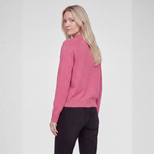 Load image into Gallery viewer, A blonde woman shown from the back wearing a pink ribbed knit sweater and dark charcoal pants, standing against a light gray studio background.