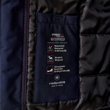 Load image into Gallery viewer, Close-up of a dark navy jacket interior showing a sewn-in label that reads 'PRO action waterproof' with red stitching along the edge.