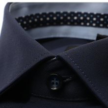 Load image into Gallery viewer, Close-up of a dark navy herringbone-patterned dress shirt collar with a matching button and a patterned inner neck lining.
