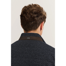 Load image into Gallery viewer, Back view of a person wearing a dark textured jacket with a visible brand label on a light background