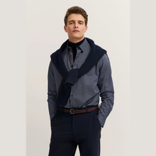 Load image into Gallery viewer, Man wearing a patterned shirt with a navy scarf and dark pants on a light background