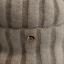 Load image into Gallery viewer, Close-up of a knitted garment featuring beige and brown stripes, finished with a small round dark brown button adorned with a delicate white embroidered monogram.