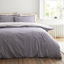 Load image into Gallery viewer, Striped duvet cover set on a bed in a bright bedroom with natural light.