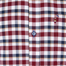 Load image into Gallery viewer, Close-up of a plaid shirt with a visible brand logo.