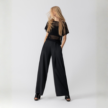 Load image into Gallery viewer, Woman wearing a black outfit with wide-leg pants on a white background