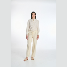 Load image into Gallery viewer, Woman wearing a beige shirt and pants on a white background