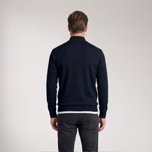 Load image into Gallery viewer, A man viewed from behind wearing a dark navy blue mock-neck knit sweater and dark gray jeans, standing against a light gray studio background.
