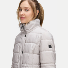 Load image into Gallery viewer, Woman wearing a light gray puffer jacket on a white background