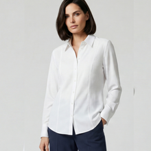 Load image into Gallery viewer, A woman modeling a white long-sleeve button-up shirt with structured shoulders, paired with navy trousers, against a plain light gray studio background.