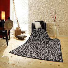 Load image into Gallery viewer, Leopard print blanket on a wooden floor with a decorative chair and lamp in the background.