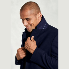 Load image into Gallery viewer, Man wearing a navy blue coat against a light gray background