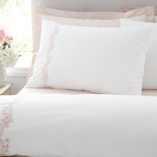 Load image into Gallery viewer, White bed with pink floral embroidery on a light background