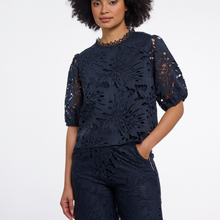 Load image into Gallery viewer, A woman wearing a navy blue lace top and matching pants against a plain white studio background.