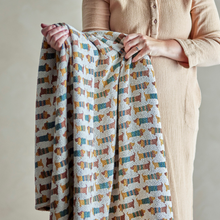 Load image into Gallery viewer, Person holding a patterned blanket with dog designs against a neutral background
