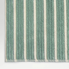 Load image into Gallery viewer, Textured green and white striped rug on a light gray background