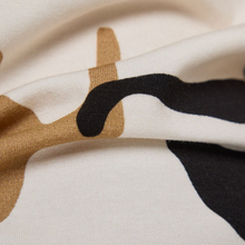 Load image into Gallery viewer, Close-up of fabric with abstract brown, black, and white pattern on a beige background