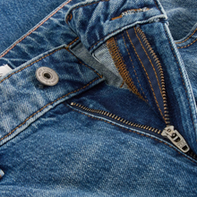 Load image into Gallery viewer, Close-up of a blue denim jacket with zipper and button details