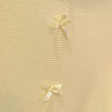 Load image into Gallery viewer, Yellow fabric with white ribbons arranged in a decorative pattern
