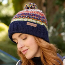Load image into Gallery viewer, A woman wearing a multicolor knit beanie with a navy blue ribbed brim and a small tan brand patch that reads 'DR. PACHYHORN'.