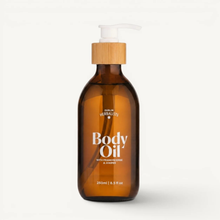 Load image into Gallery viewer, Brown bottle of body oil with a wooden pump on a white background