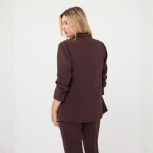Load image into Gallery viewer, A woman with blonde hair is shown from the back wearing a dark brown tailored blazer and matching trousers against a plain white studio background.