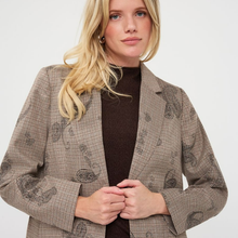 Load image into Gallery viewer, A blonde woman wearing a brown and beige patterned blazer over a dark brown mock neck top, photographed against a clean white studio background.