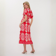 Load image into Gallery viewer, Woman wearing a red dress with white patterns on a white background