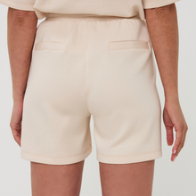 Load image into Gallery viewer, Beige shorts worn by a person on a white background