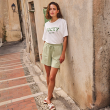 Load image into Gallery viewer, Lady in shorts and t-shirt on a street scene